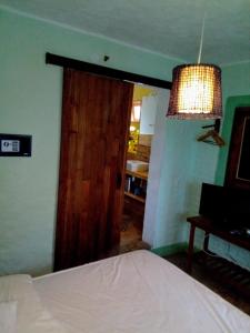 - une chambre avec un lit et une grande porte en bois dans l'établissement Maria Teresa Bragança Pousada, à Jericoacoara