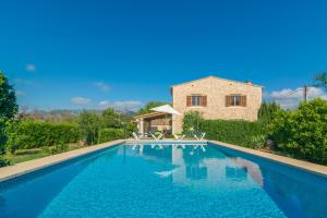 a villa with a swimming pool in front of a house at Can Tut in Campanet