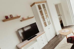 un salon avec une télévision à écran plat fixée au mur dans l'établissement Apartment Strandnüst, à Aurich