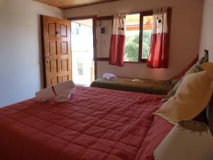 1 dormitorio con 1 cama grande y edredón rojo en Vista Serrana en Alpa Corral