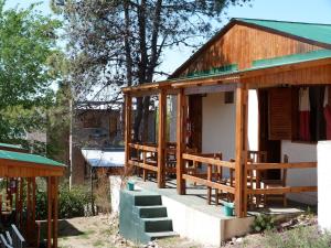 una casa con techo verde y escaleras a ella en Vista Serrana en Alpa Corral