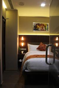 a bedroom with a bed and a lamp at Hotel Clover 5 HongKong Street (SG Clean) in Singapore