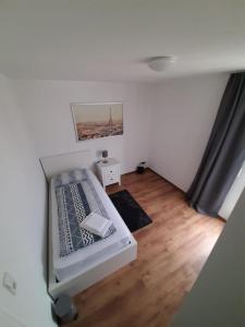 a small bedroom with a bed and a wooden floor at Sophies Apartment in Stuttgart