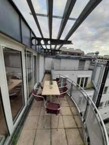- un balcon avec une table et des chaises dans un bâtiment dans l'établissement Sophies Apartment, à Stuttgart