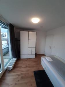 Habitación vacía con ventana grande y puerta en Sophies Apartment, en Stuttgart