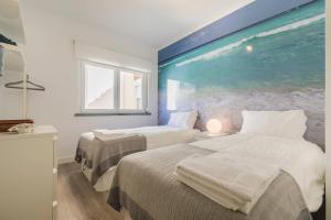 duas camas num quarto com um quadro na parede em Cozy Seaview Apartment em Parede