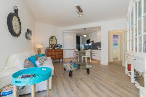 Cozy Seaview Apartment في باريد: غرفة معيشة مع أريكة بيضاء وساعة على الحائط