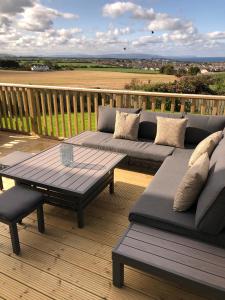 a patio with couches and a table on a deck at Portview in Portrush