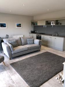 a living room with a couch and a kitchen at Portview in Portrush