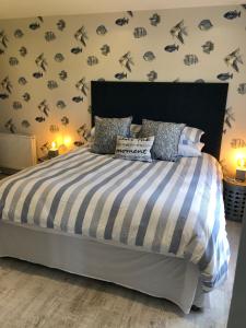 a bedroom with a bed with a black and white comforter at Portview in Portrush