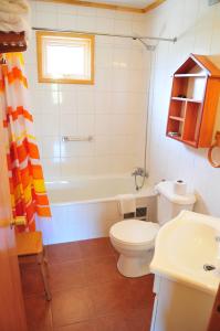 e bagno con servizi igienici, vasca e lavandino. di Cabañas Trayen a Castro Altre 37 foto