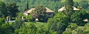 a house in the middle of a field with trees at Le Silve di Armenzano in Assisi