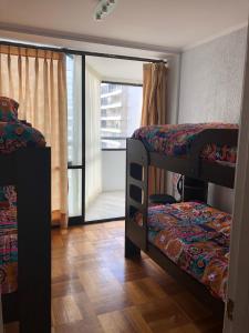 a room with two bunk beds and a balcony at Muelle Vergara view in Viña del Mar