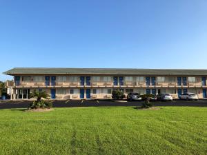 a large building with a large lawn in front of it at Motel 6-Clute, TX in Clute
