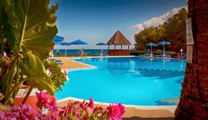 a swimming pool with blue water and blue umbrellas at Camping Nopigia in Kissamos