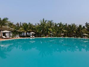 una gran piscina azul con palmeras en el fondo en Lang Co Beach Resort, en Lang Co