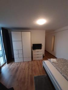 a bedroom with a bed and a dresser and a television at Sophies Apartment in Stuttgart