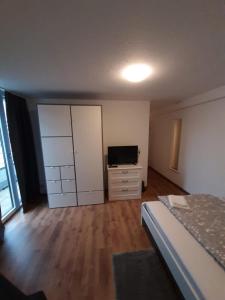 a bedroom with a bed and a dresser and a television at Sophies Apartment in Stuttgart +2 photos