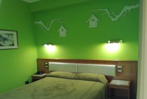 a bedroom with a green wall with a bed and lights at FILIPPONE HOTEL&RISTORANTE in Gioia dei Marsi