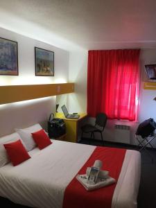 a hotel room with a bed with a red curtain at Quick Palace Poitiers in Chasseneuil-du-Poitou