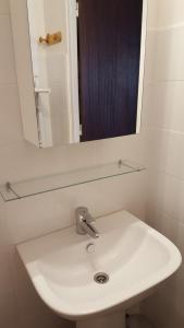 ein weißes Waschbecken im Bad mit Spiegel in der Unterkunft Eperon 1 in Les Deux Alpes