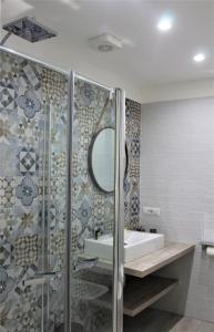 La salle de bains est pourvue d'un lavabo et d'une douche avec un miroir. dans l'établissement Anima Migrante, à Naples