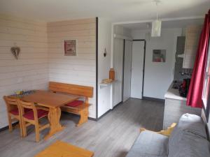 a living room with a wooden table and a kitchen at Belle Plagne 1 Appart 6 pers du Dimanche au Dimanche Ski au pieds in La Plagne