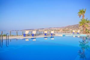 a large swimming pool with a view of the ocean at Poseidon of Paros Hotel & Spa in Chrissi Akti