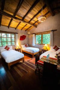 Un dormitorio con 2 camas y una mesa en una habitación en Sacred Dreams Lodge, en Urubamba