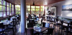 a dining room with tables and chairs and windows at Central Hotel-Apart München in Munich