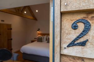 a room with a bed and a number on the door at The Chequers at Burcot in Oxford