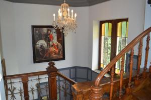 eine Treppe mit einem Kronleuchter und einem Gemälde an der Wand in der Unterkunft B&B Chatelet Cremers in Verviers