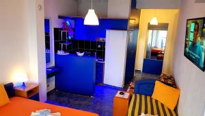 een blauwe keuken met een bank en een tafel in een kamer bij Malibu Apartments in Sutomore