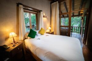 a bedroom with a large white bed and a window at Sacred Dreams Lodge in Urubamba