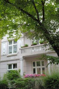 une maison blanche avec un balcon et des fleurs roses dans l'établissement Hotel Mare, à Hambourg