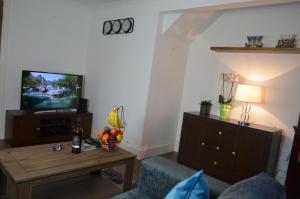 ein Wohnzimmer mit einem TV und einem Couchtisch in der Unterkunft Mundy House in Swindon