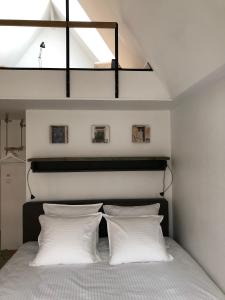 een slaapkamer met een bed met witte kussens bij B&B Calis in Brugge