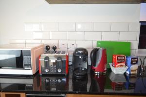 a kitchen counter with a microwave and appliances on it at Mundy House in Swindon