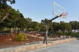 an outdoor basketball hoop in a park with trees at Villa Shanti - Pool, Beach & Basketball court in Luštica +48 photos