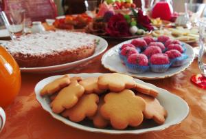 a table topped with plates of cookies and desserts at B&B La Ginestra in Civita