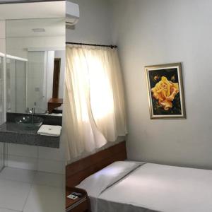 1 dormitorio con 1 cama y baño con lavamanos en Hotel Itamarati, en Uberlândia