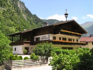 un edificio con flores a un lado. en Haus Niklehen, en Hüttschlag