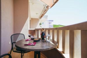 een klein tafeltje met twee glazen wijn op een balkon bij Villa Promajna 5 in Promajna