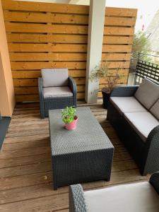 eine Terrasse mit 2 Stühlen, einem Tisch und einem Sofa in der Unterkunft APPARTEMENT CENTRE VILLE AVEC TERRASSE ET PARKING SECURISE in Rennes