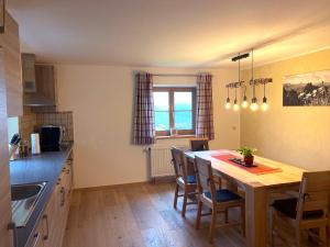 a kitchen with a wooden table and a dining room at Allgäu-Feeling in Rettenberg