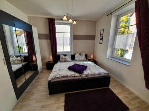 ein Schlafzimmer mit einem Bett und einem großen Spiegel in der Unterkunft Ferienwohnung Sonneberg in Sonneberg
