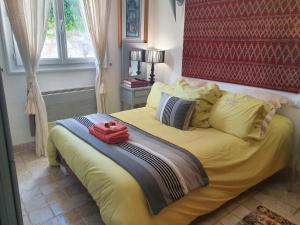 a bedroom with a yellow bed with a red headboard at maison de charme avec piscine et vue exceptionnelle in Scolca +39 photos