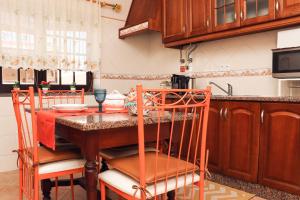 een keuken met een houten tafel en stoelen bij Casa Beta in Peniche