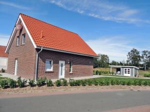 a brick house with an orange roof at Ferienhaus Schomaker in Rieste