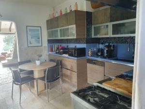 a kitchen with a table with chairs and a stove at maison de charme avec piscine et vue exceptionnelle in Scolca